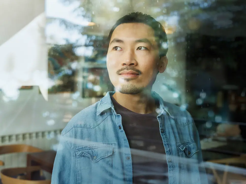 A man looks through a glass window.